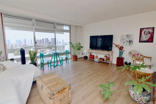 a living room with patio furniture and a flat screen tv
