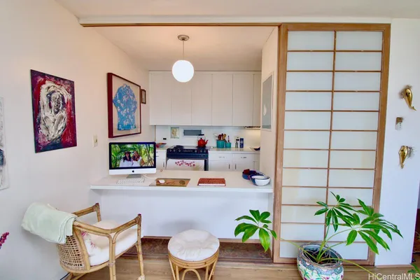 a dining room with furniture and a potted plant