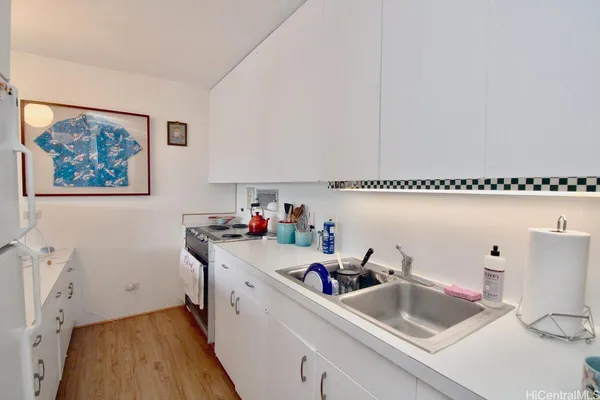 a kitchen with sink cabinets and wooden floor