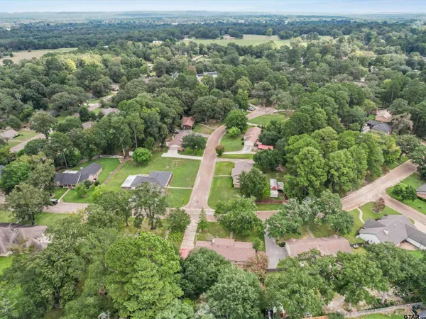 an aerial view of residential house with outdoor space and trees all around