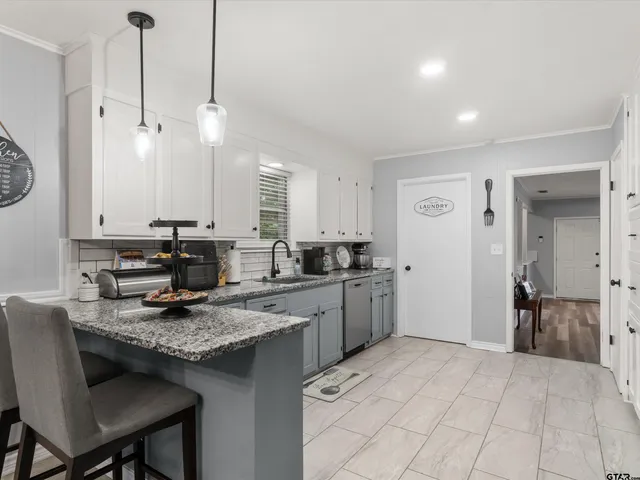 a kitchen with a stove a refrigerator a sink and chairs