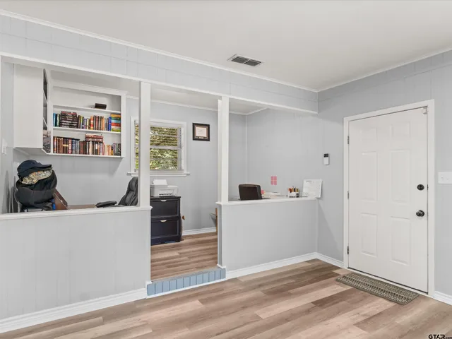 a view of a kitchen with fridge and wooden floor
