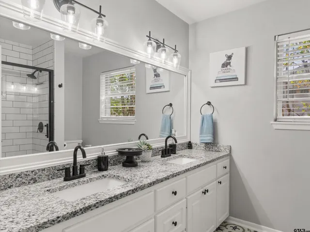 a bathroom with double sink and a mirror