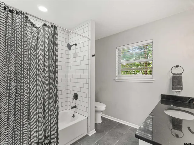 a bathroom with a shower curtain and a sink