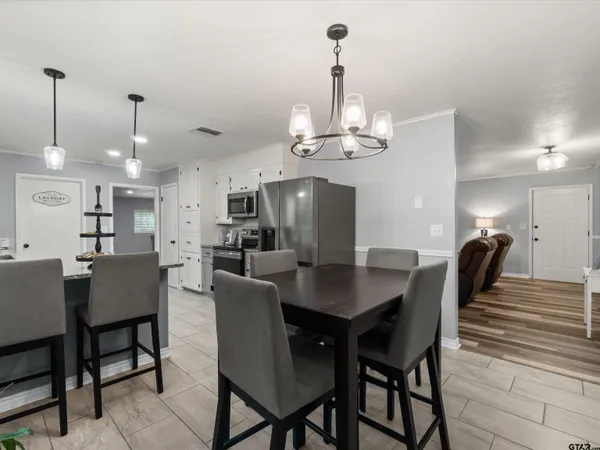 a view of a dining room and livingroom with furniture wooden floor a chandelier