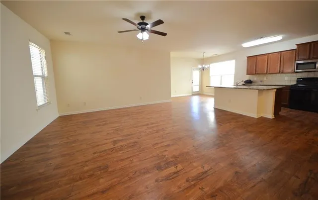 a kitchen with stainless steel appliances granite countertop a refrigerator a sink dishwasher a stove with wooden floor and cabinets