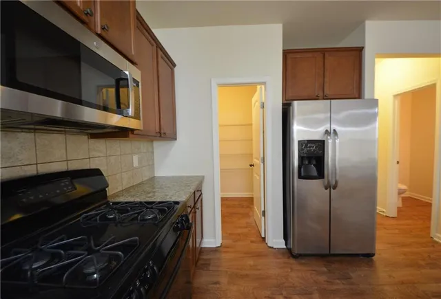 a kitchen with granite countertop stainless steel appliances and wooden cabinets