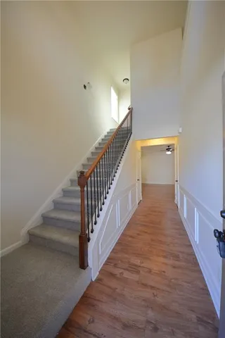 a view of a hallway with wooden floor and stairs