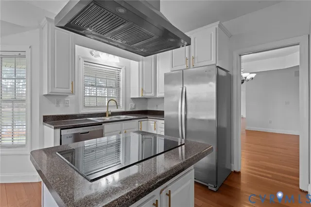 a kitchen with granite countertop a sink stainless steel appliances and window