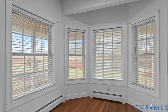 a view of a room with wooden floor and windows