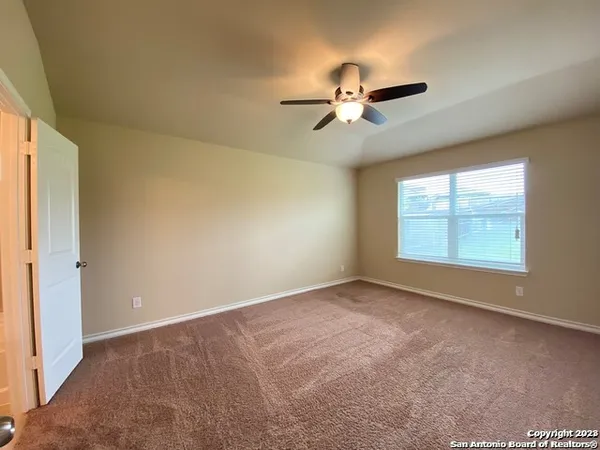 an empty room with windows and fan view