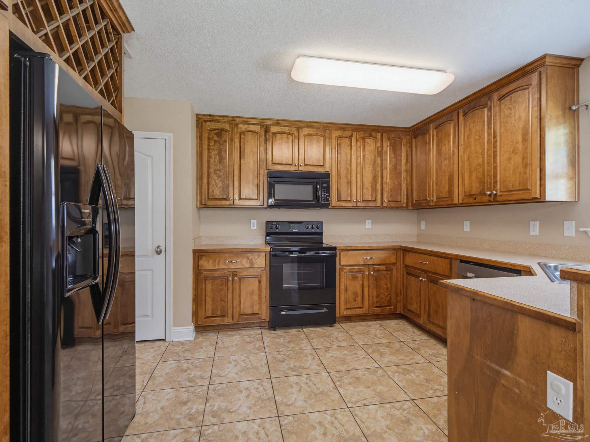 5567 Jones Street Milton, FL 32570 - Photo 16 of 48 a kitchen with a refrigerator sink and stove top oven