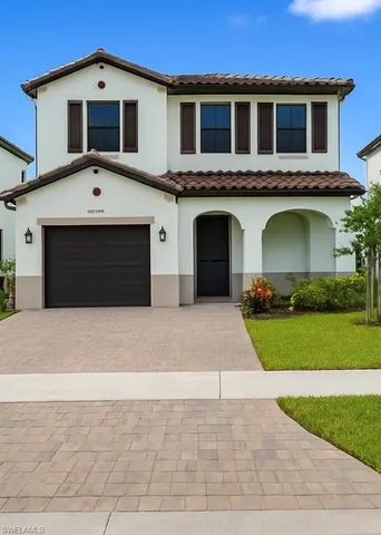 a front view of a house with a yard and a garage