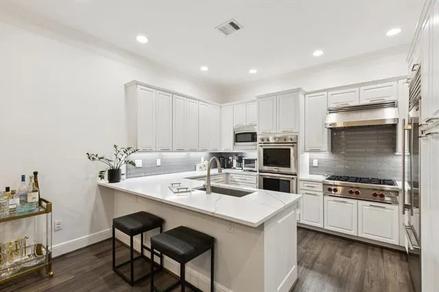 a kitchen with a sink stainless steel appliances and white cabinets