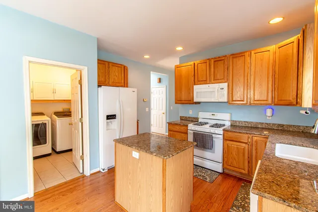 a kitchen with stainless steel appliances granite countertop a refrigerator a stove top oven a sink and dishwasher