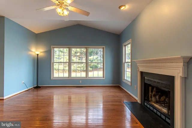 a view of an empty room with window and fire place
