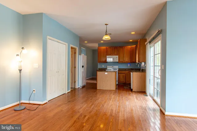 a kitchen with stainless steel appliances kitchen island wooden floors and granite counter tops