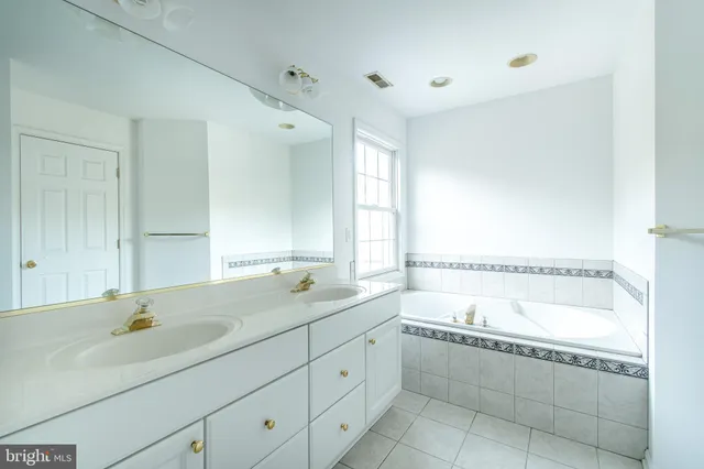 a bathroom with a tub sink and mirror