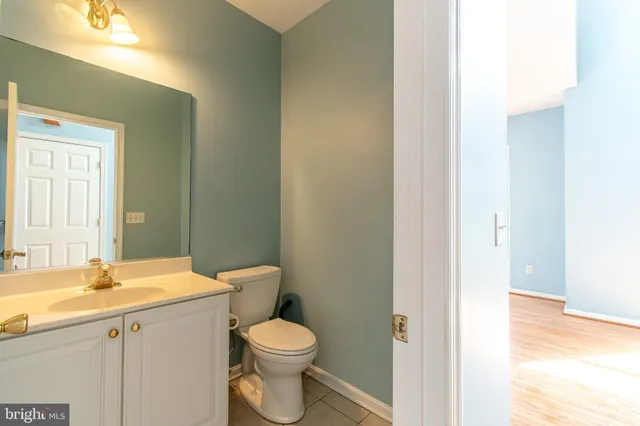 a bathroom with a granite countertop toilet a sink and a mirror