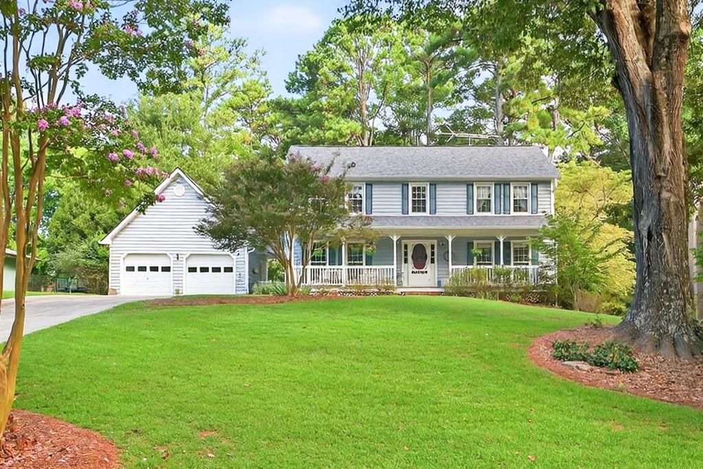 a front view of a house with a yard and trees