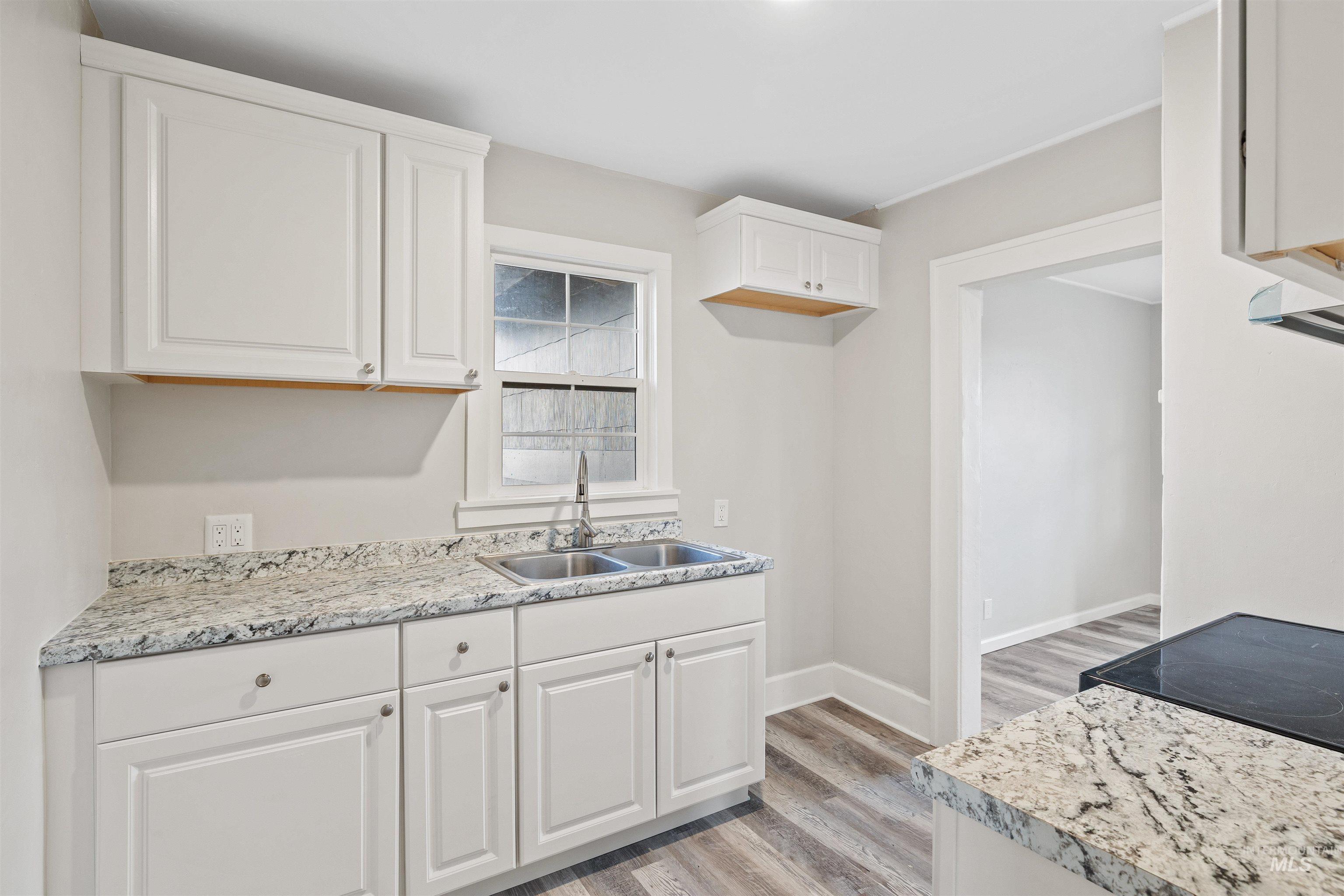617 Eden Street North Twin Falls, ID 83301 - Photo 8 of 25 Kitchen featuring light countertops, white cabinetry, and light wood finished floors