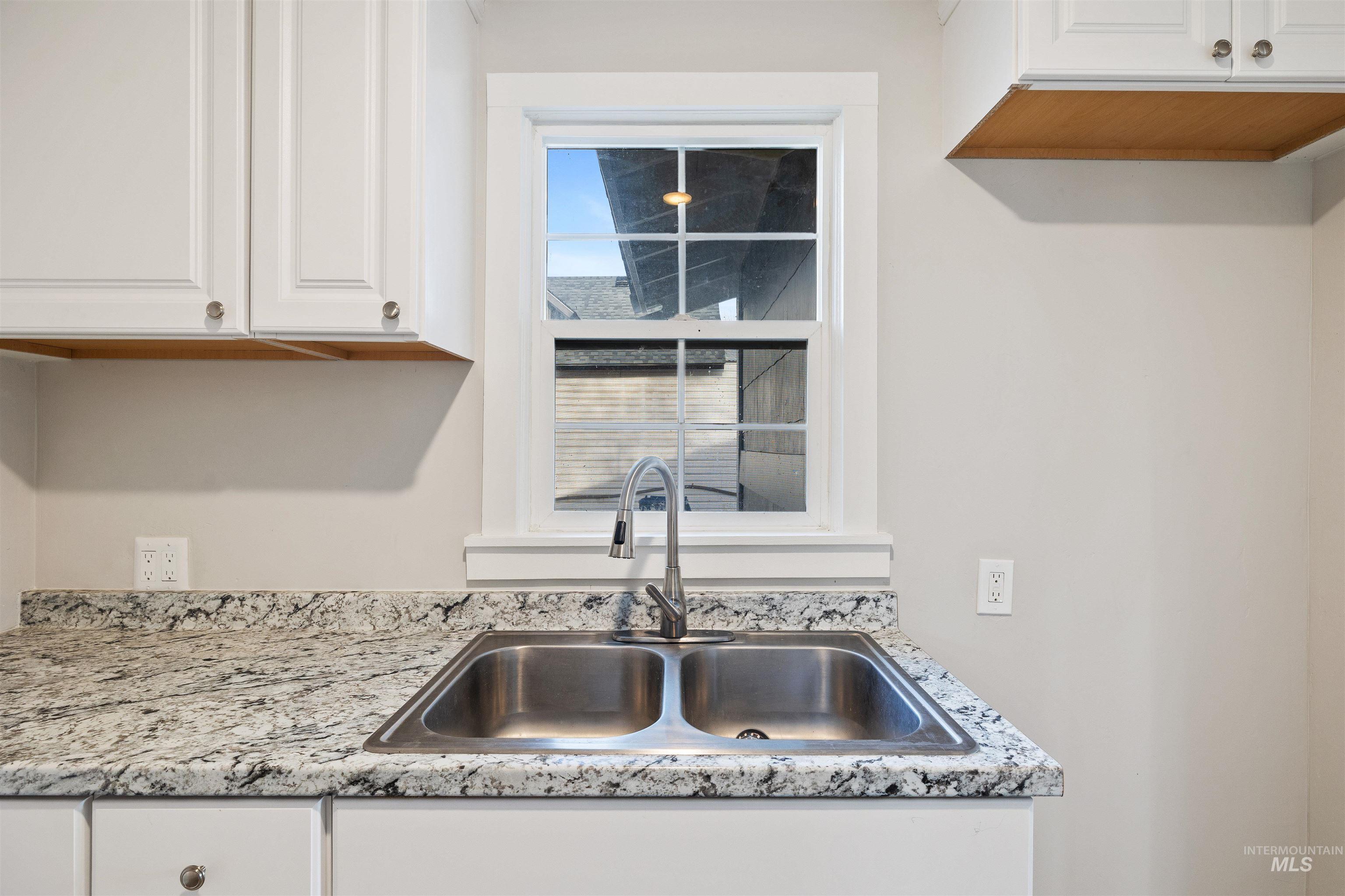 617 Eden Street North Twin Falls, ID 83301 - Photo 9 of 25 Kitchen featuring white cabinetry and light stone countertops
