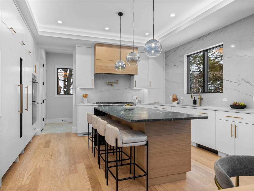38 Kappius Path Newton, MA 02459 - Photo 3 of 13 a kitchen with stainless steel appliances granite countertop a sink a stove a refrigerator and island with wooden floor