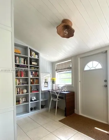 a room with granite countertop white cabinets and window
