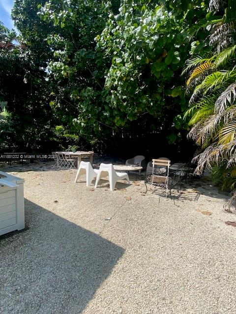 2952 Virginia Street Miami, FL 33133 - Photo 9 of 10 a view of backyard with a table and chairs