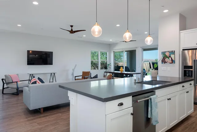 a kitchen with granite countertop a sink a counter space appliances and cabinets