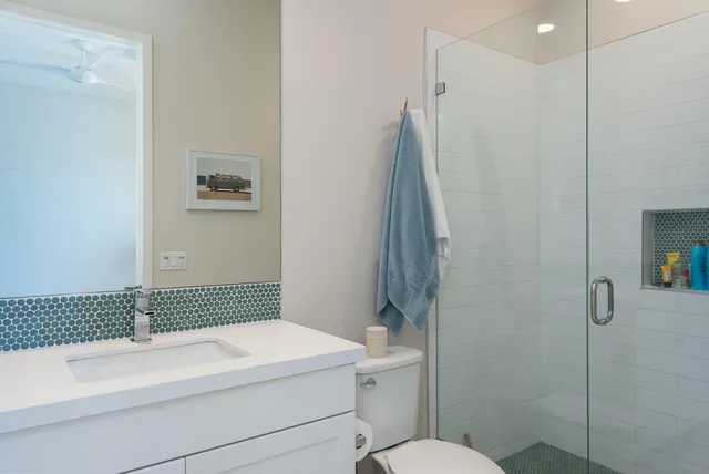 a bathroom with a sink a toilet a shower and a mirror