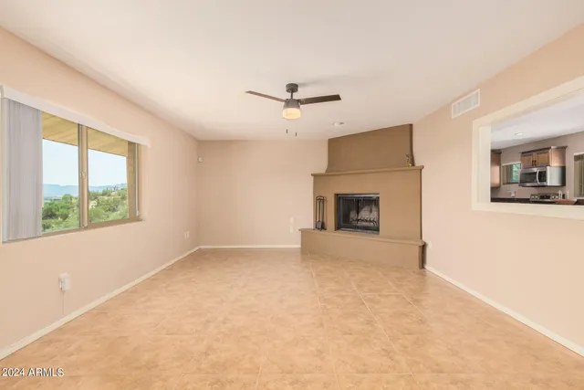 an empty room with windows and fireplace