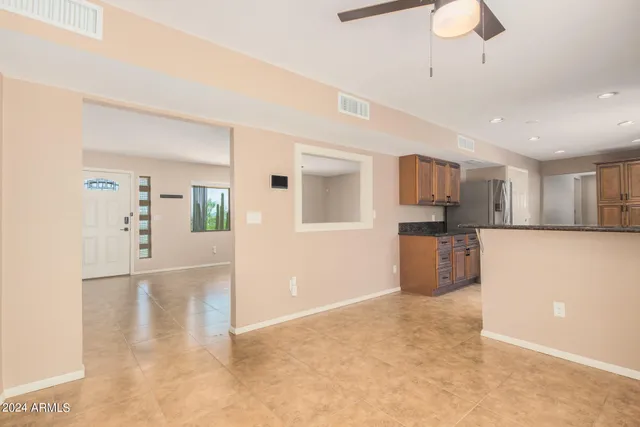 a view of a kitchen with refrigerator and white cabinets