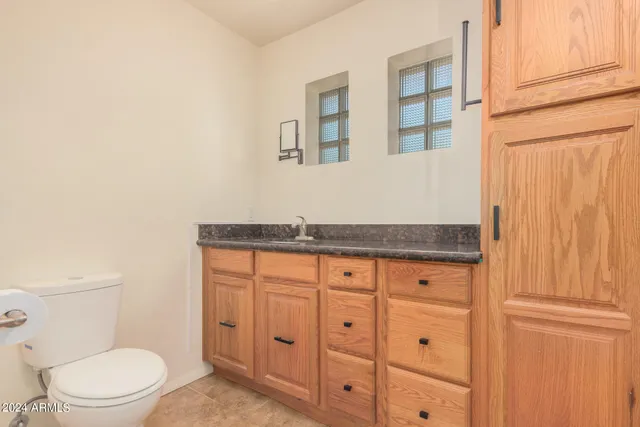 a bathroom with a granite countertop toilet and sink