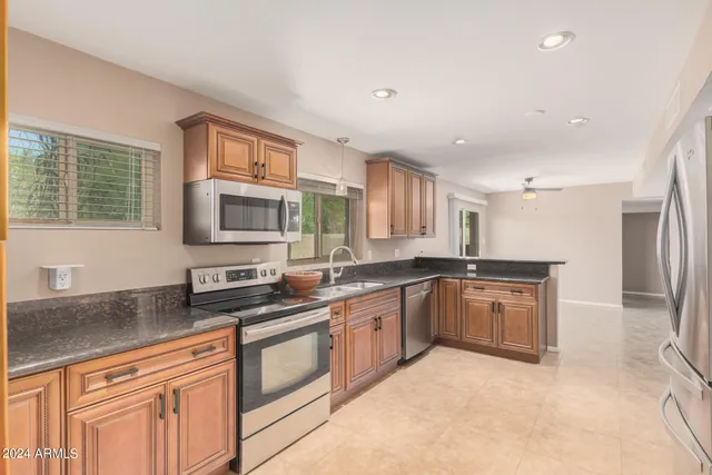 a kitchen with stainless steel appliances granite countertop a stove sink and cabinets