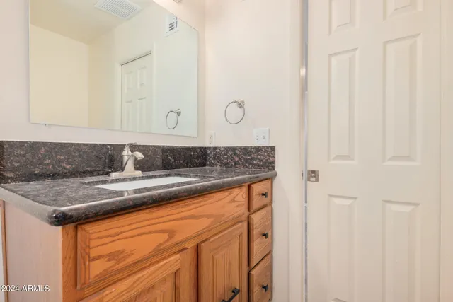 a view of a sink a mirror and cabinets