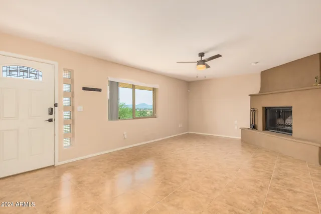 a view of an empty room with a fireplace and a window