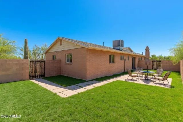 a view of a backyard with chairs potted plants and wooden fence