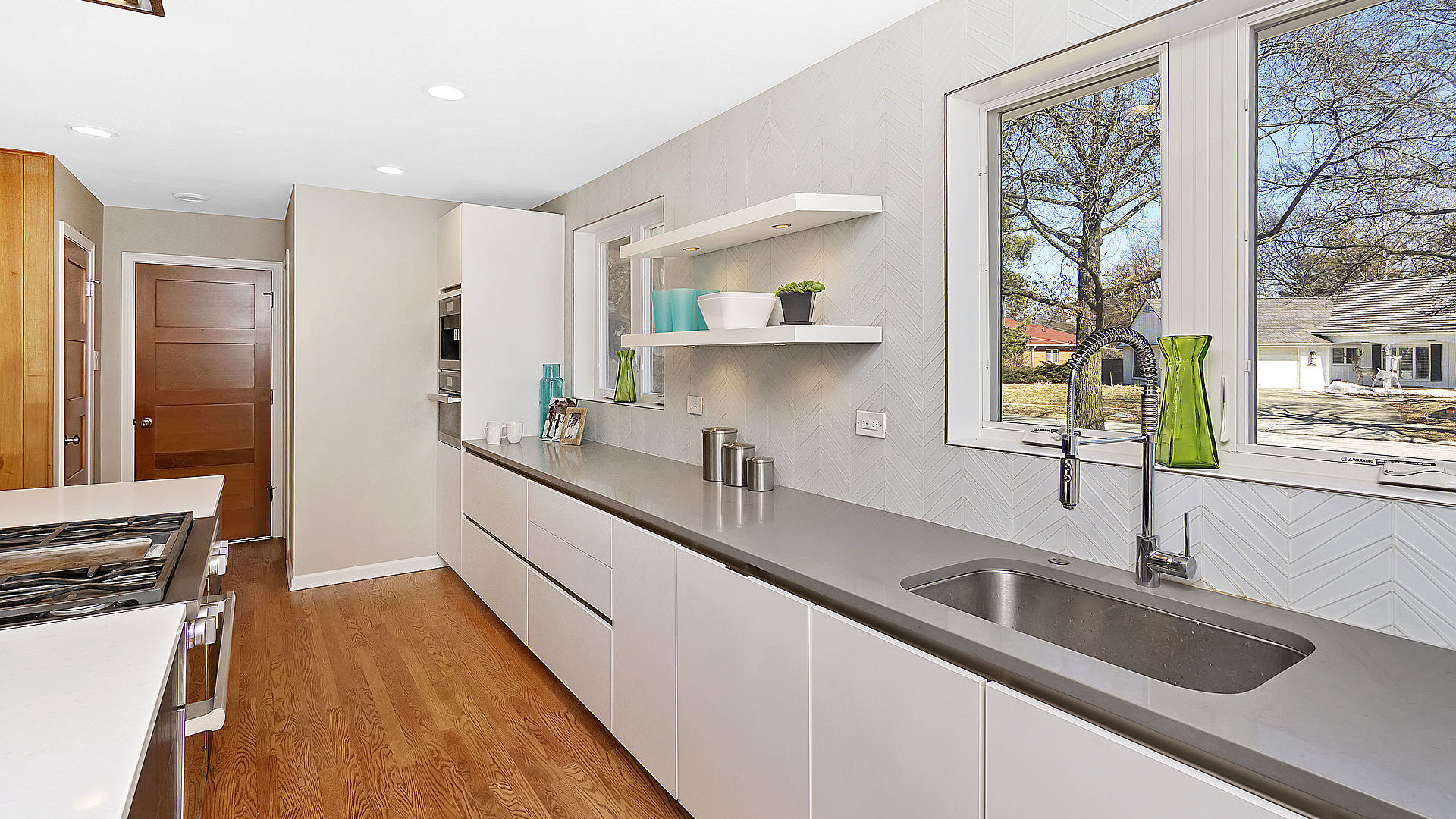 352 Gatesby Road Riverside, IL 60546 - Photo 6 of 18 a kitchen with stainless steel appliances a sink a stove and a wooden floor