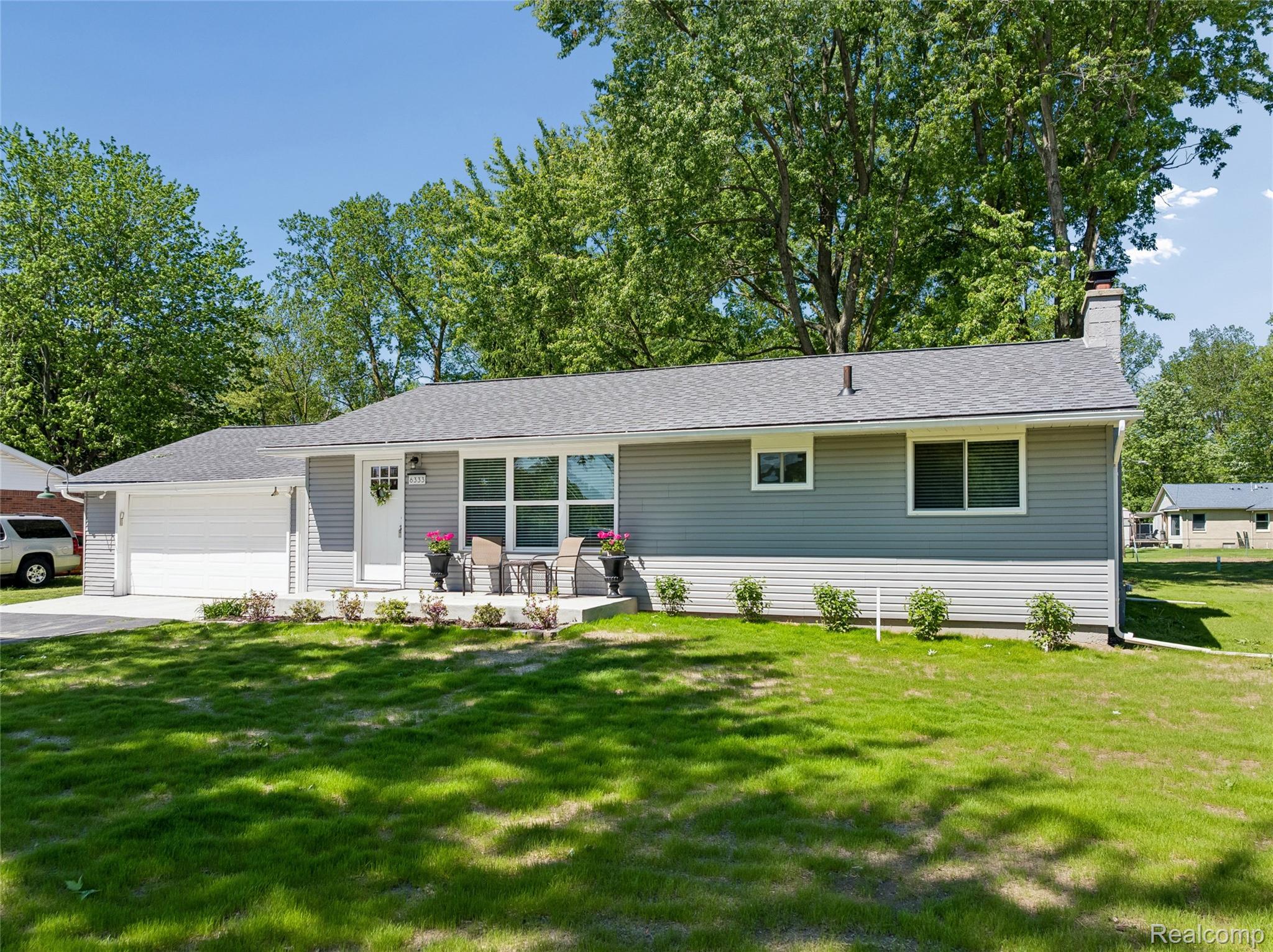 6333 North Beck Road Canton, MI 48187 - Photo 3 of 26 Single story home with a garage, a front yard, a chimney, concrete driveway, and roof with shingles