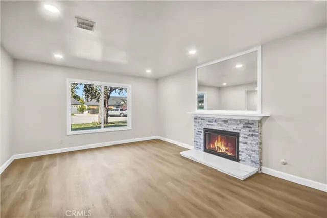 an empty room with windows and fireplace