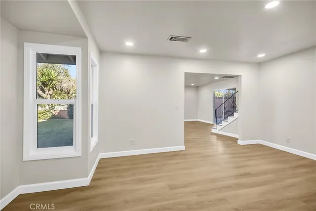 an empty room with wooden floor and a window
