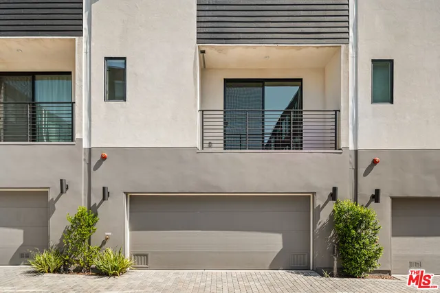 a front view of a house with plants