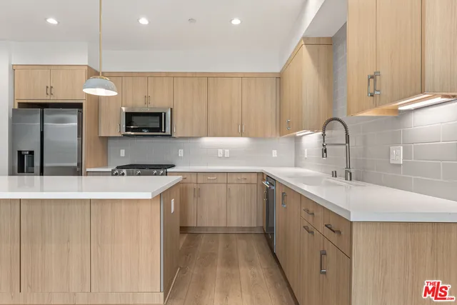 a kitchen with stainless steel appliances a sink stove and cabinets