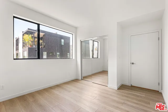an empty room with wooden floor and a window
