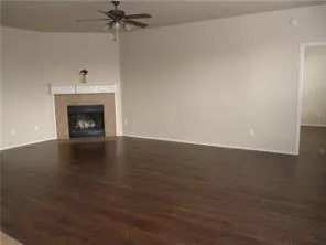 an empty room with a fireplace and wooden floor