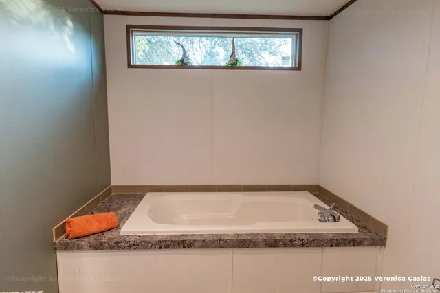 a bathroom with a granite countertop sink and mirror
