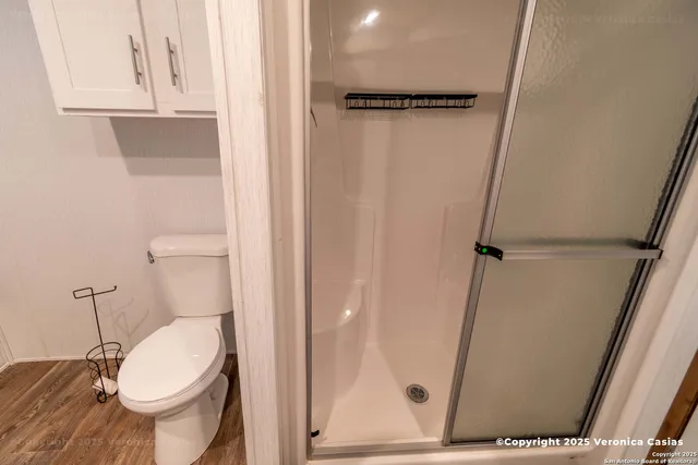 a white toilet sitting next to a shower