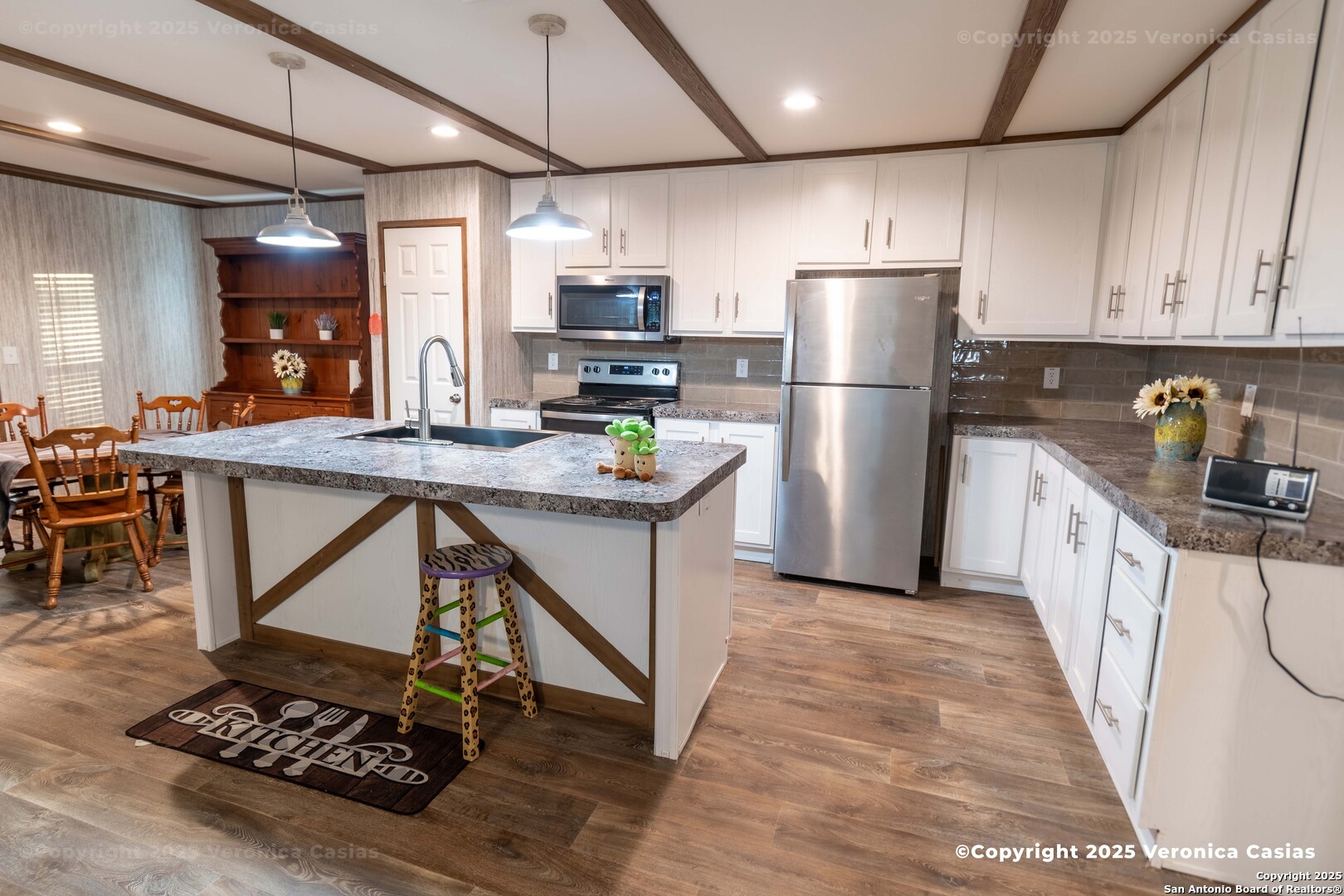 336 County Road 6846 Lytle, TX 78052 - Photo 5 of 20 a kitchen with stainless steel appliances kitchen island granite countertop a refrigerator a stove a sink a dining table and chairs with wooden floor