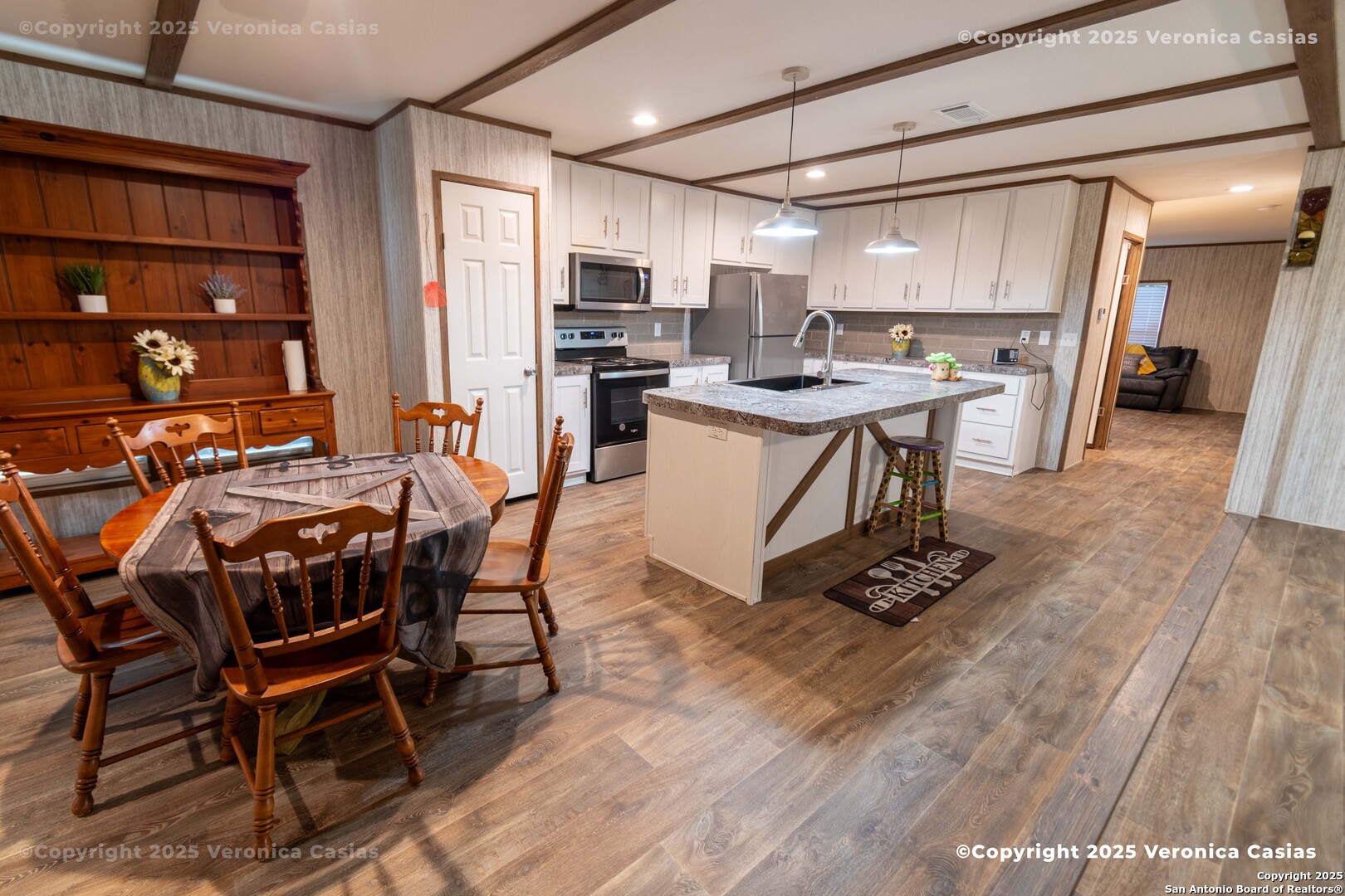 336 County Road 6846 Lytle, TX 78052 - Photo 6 of 20 a kitchen with stainless steel appliances kitchen island granite countertop a table chairs sink and cabinets